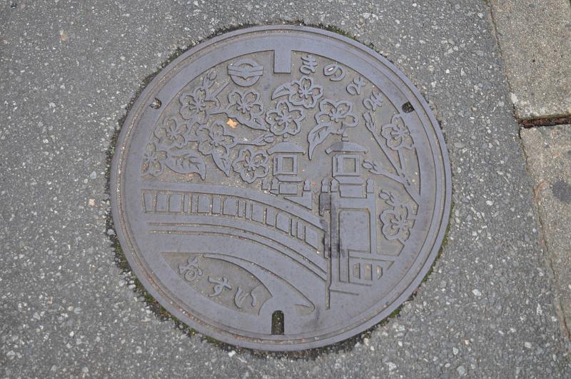 foto_20111108_1453_01.jpg - [de]Da Onsen so schlecht abzubilden sind, sind eben die schönen Steinbrücken und Laternen auf den Gullideckeln verewigt.[en]Since Onsen are not so easy to depict, they chose the nice stone bridges and lanterns for the sink covers.